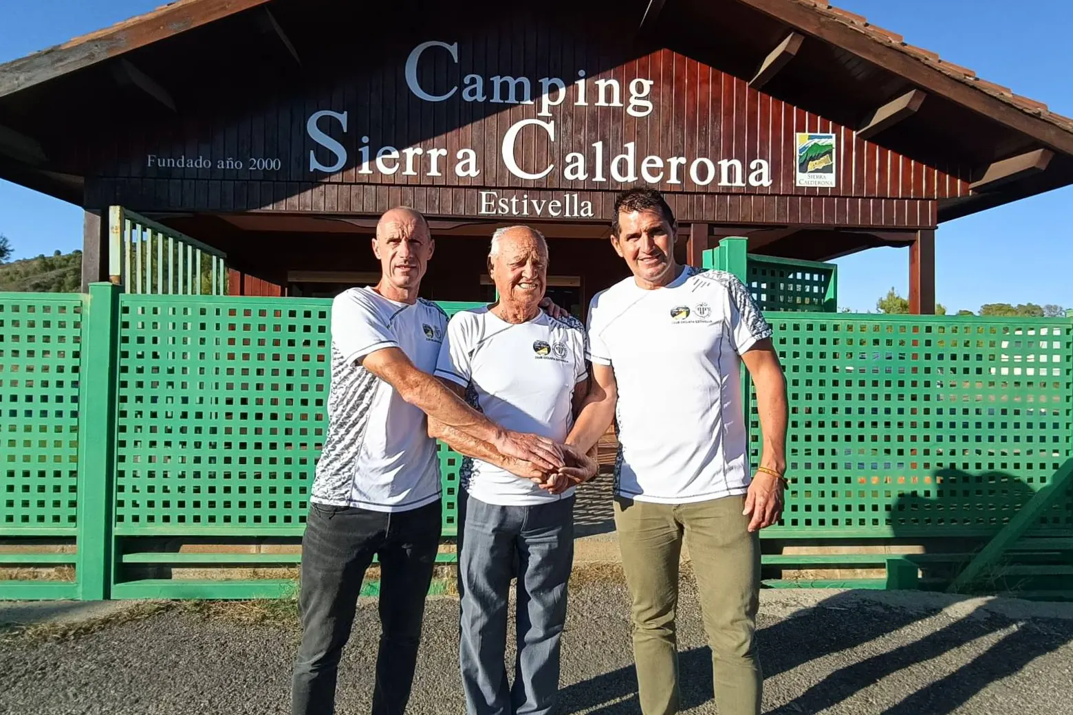 José Sáez, José Ramón Mateu y Rafa Casero unen las manos ante la entrada del Camping Sierra Calderona, en Estivella